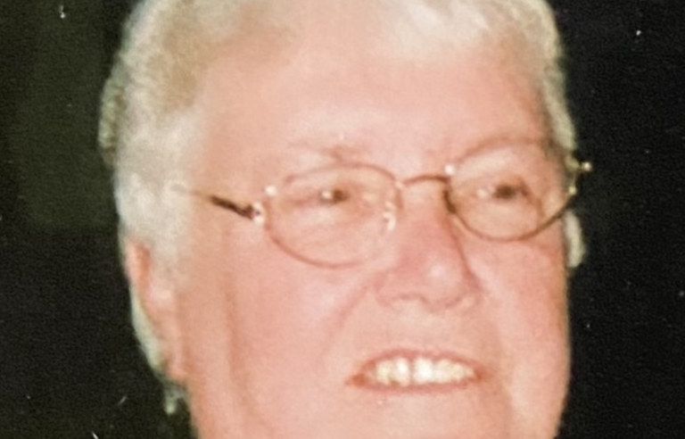 An older woman with short white hair and glasses