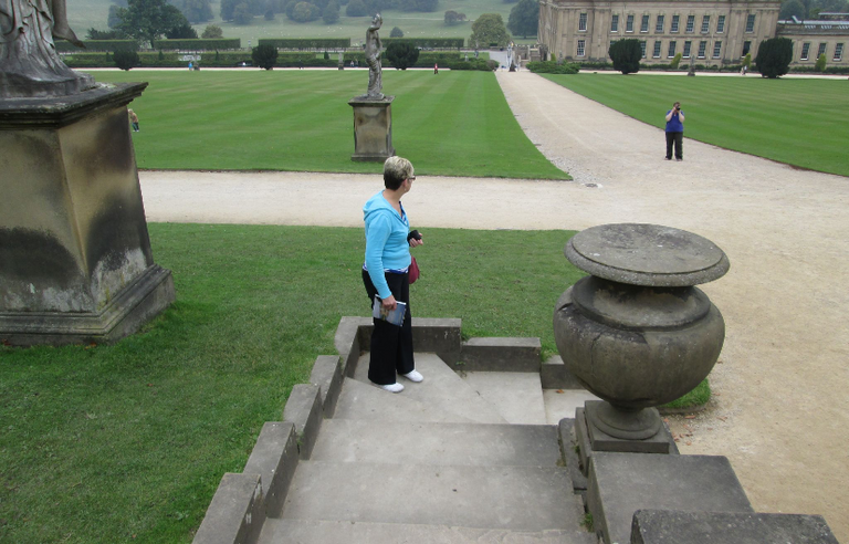A woman wearing a blue top in a country estate