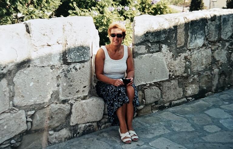 A woman sat on a stone wall