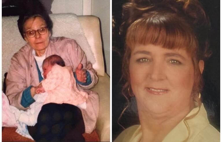 A woman with short brown hair and glasses holding a baby dressed in pink and a lady with her brown hair in a bun smiling a the camera