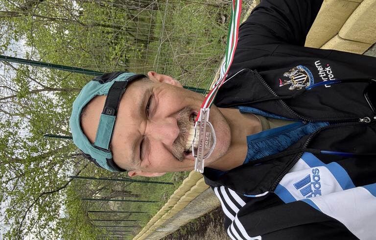 A man with a backwards green cap and an navy Adidas jacket