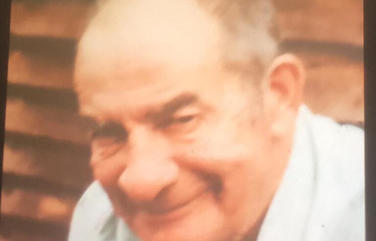 An older man wearing a light blue shirt