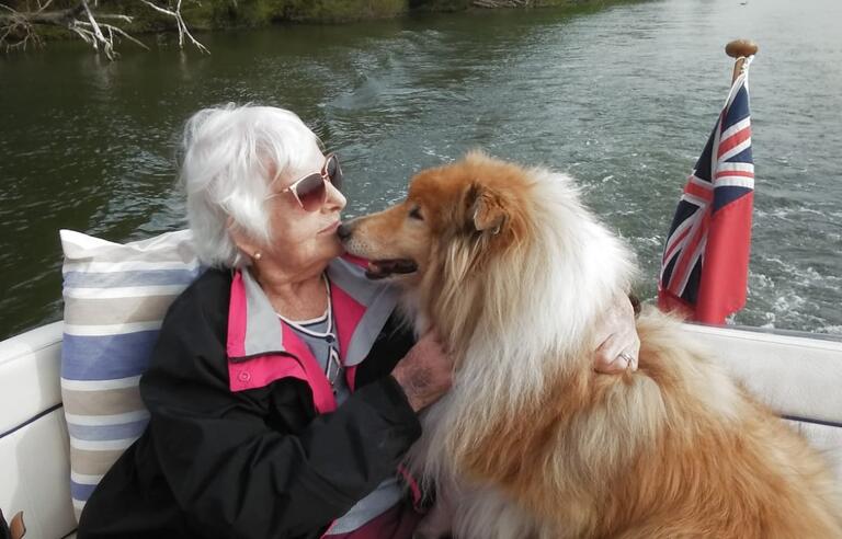A woman with a dog on a boat on water